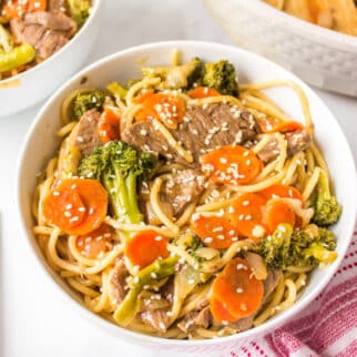 A white bowl of gluten-free teriyaki beef with noodles.