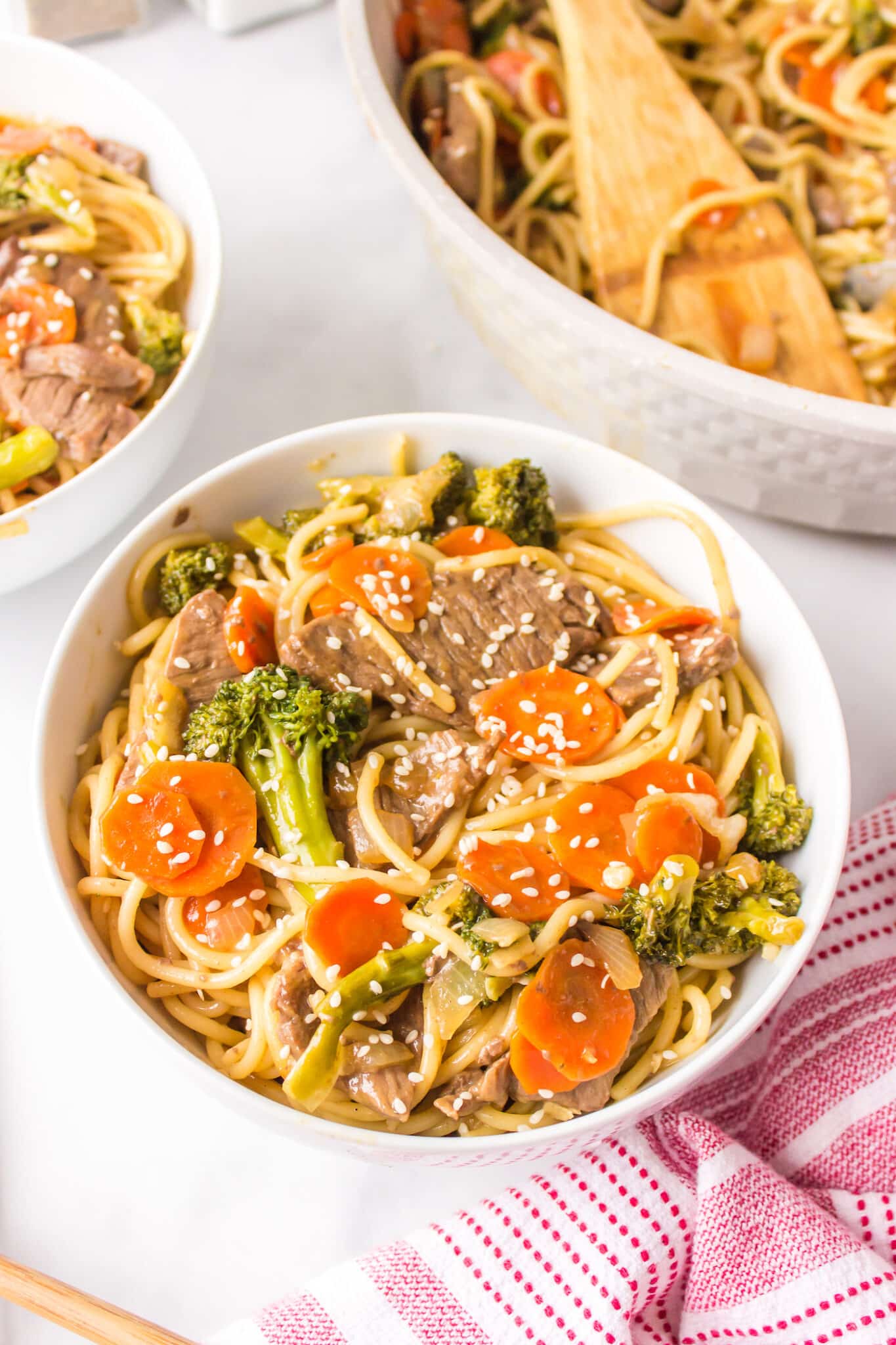 A white bowl of gluten-free teriyaki beef with noodles.