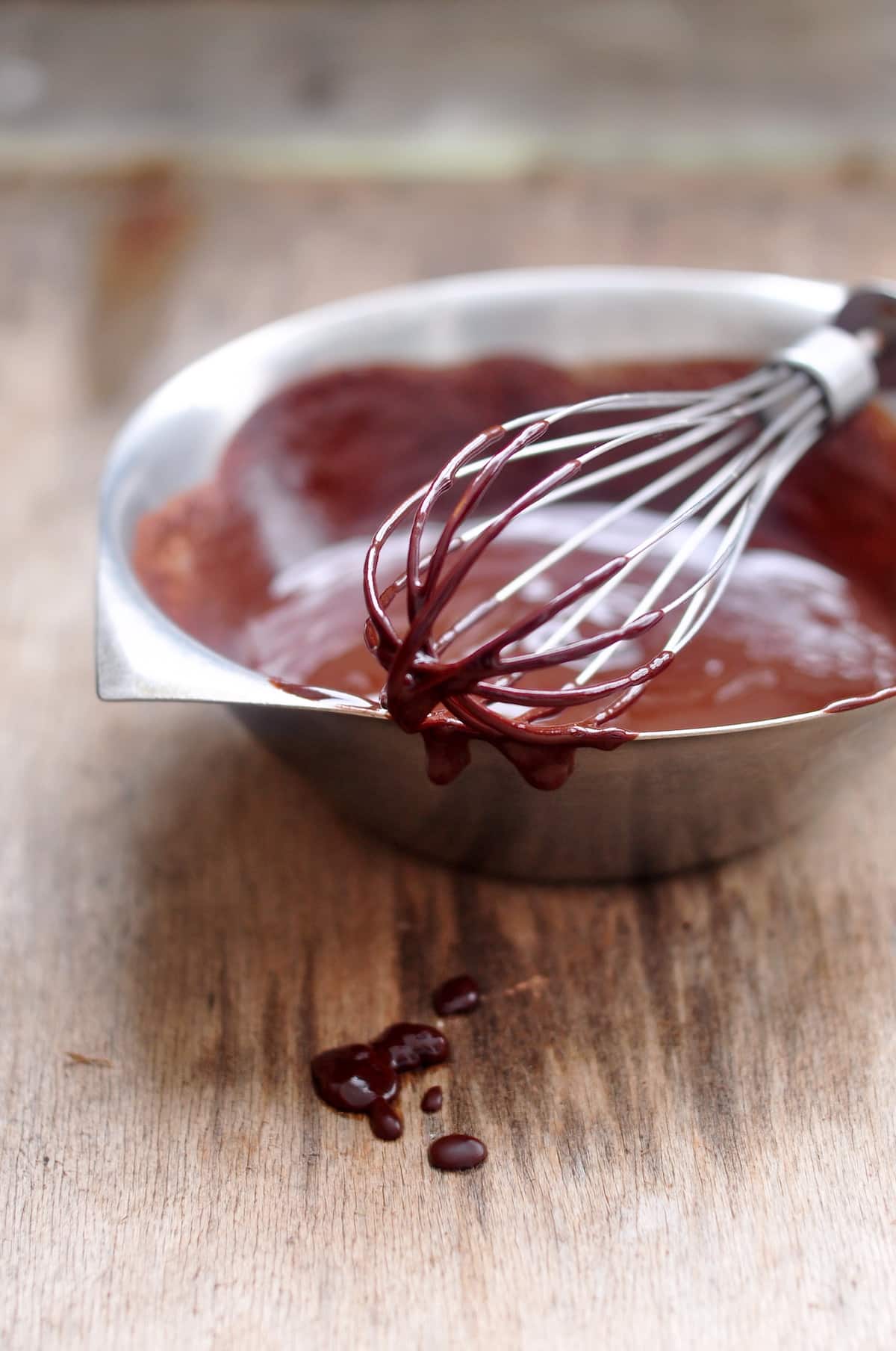 melted chocolate in stainless steel bowl with whisk.