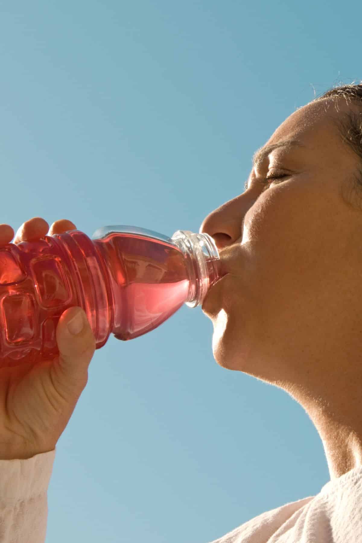 a woman drinking out of a Gatorade bottle.
