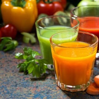 colorful veggie juices on table.