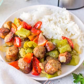 air fryer sausage and peppers on a white plate with rice.