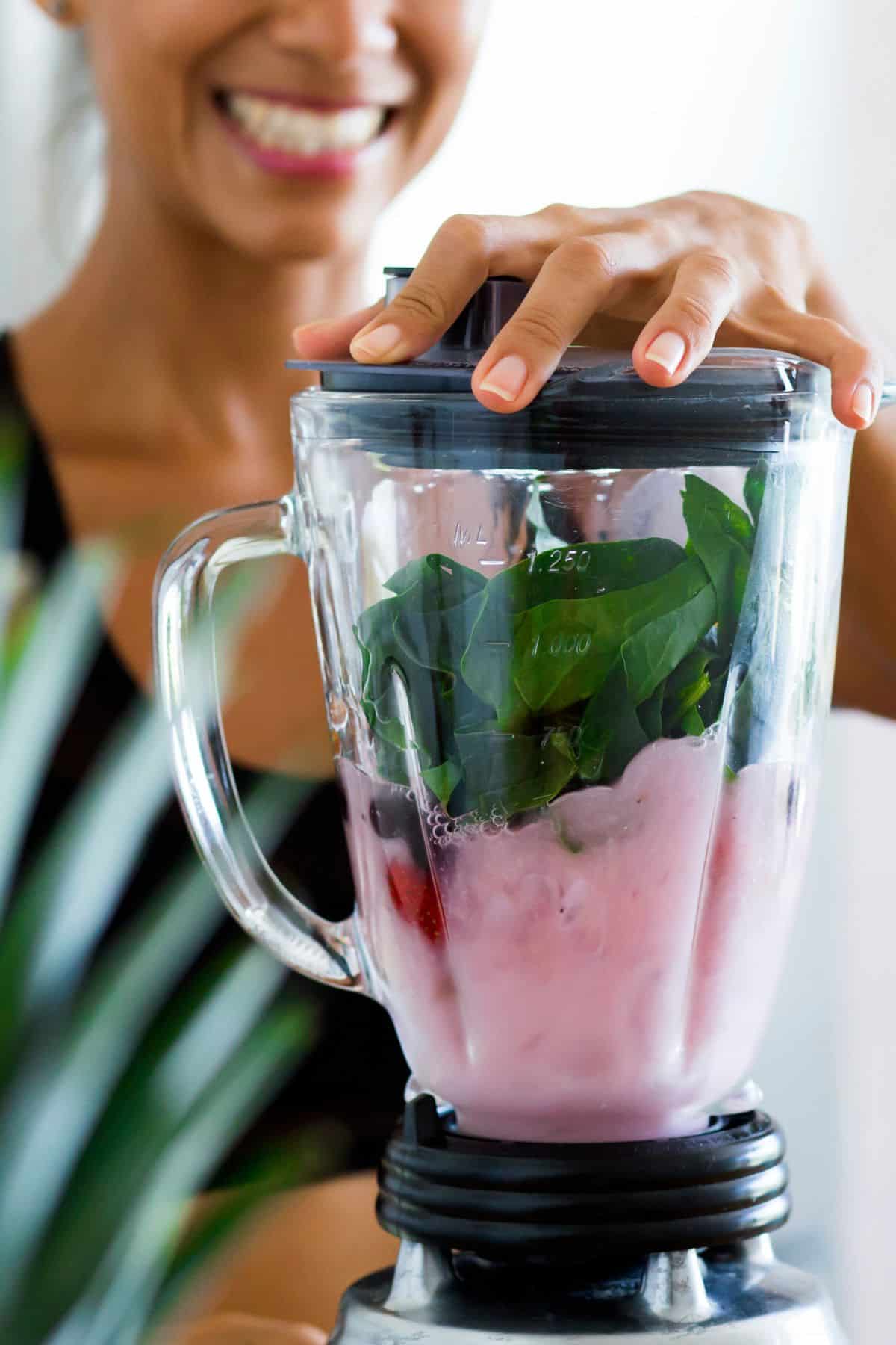 a woman using a blender.