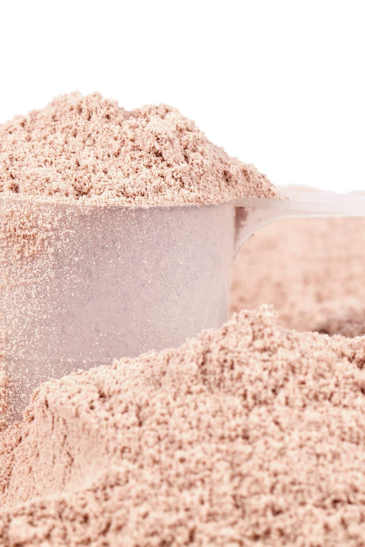 a scoop of whey protein isolate sitting on a mound of whey protein isolate.