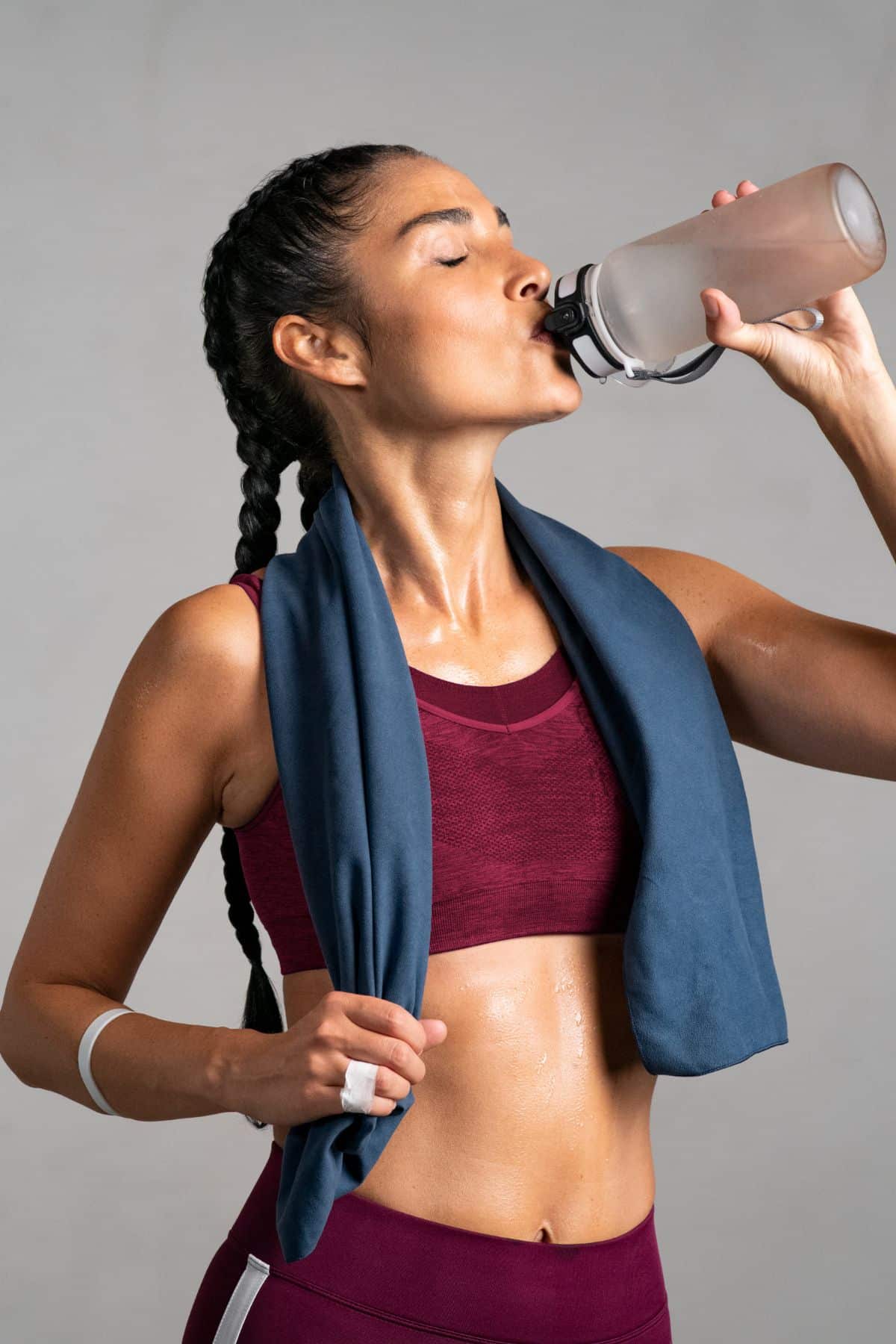 a woman hydrating after exercising. 