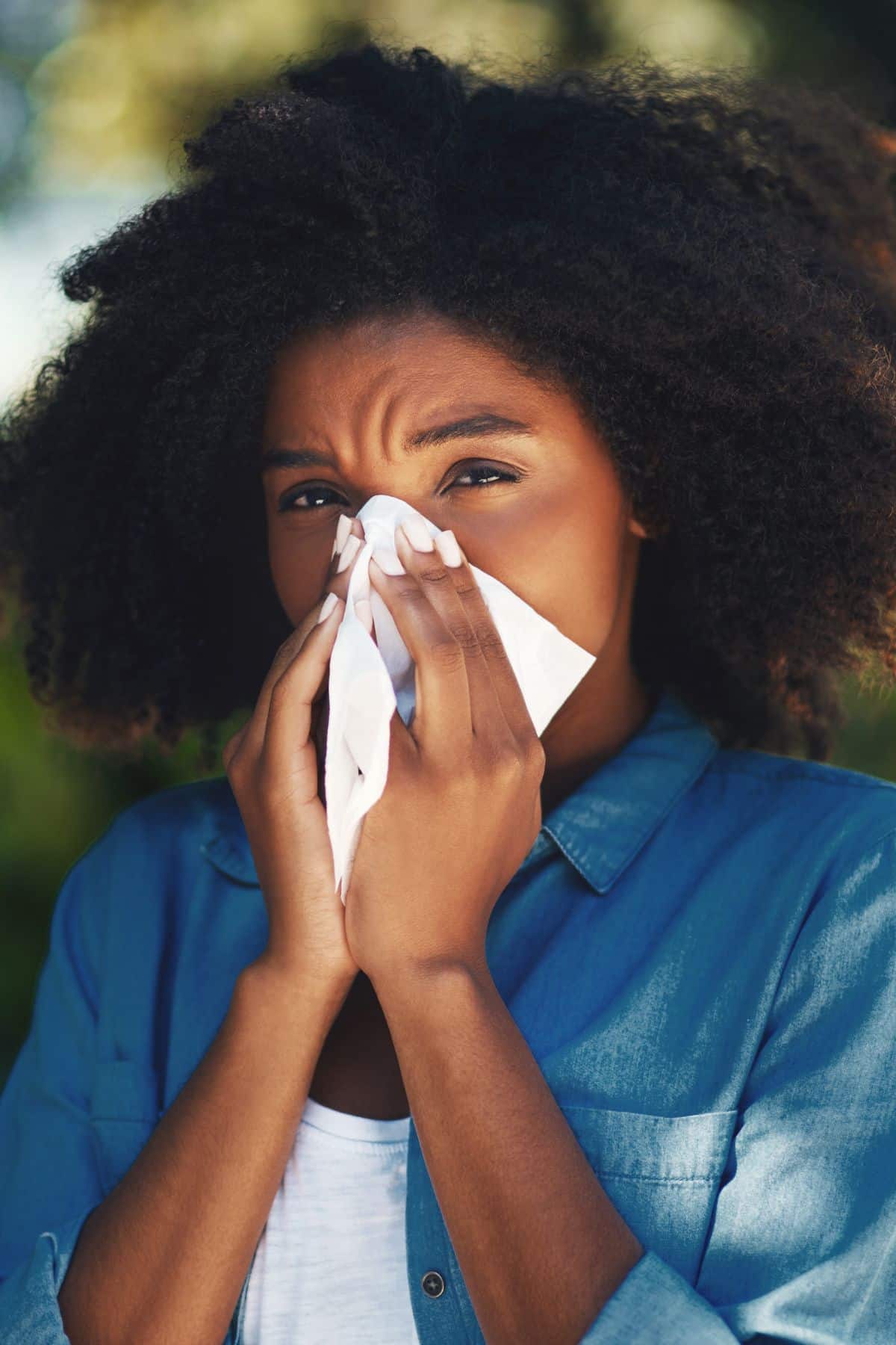 a woman with a tissue to her nose.