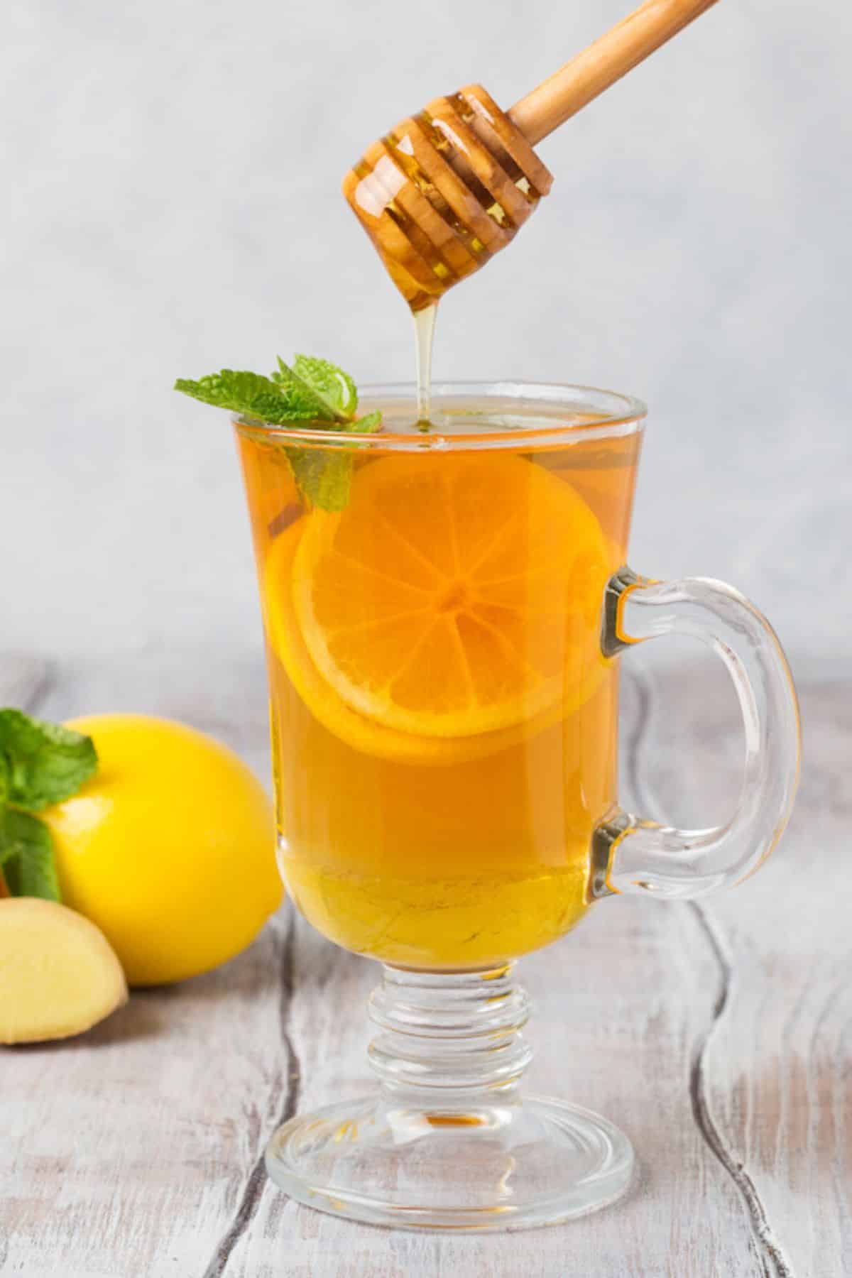 clear mug with honey lemon tea.