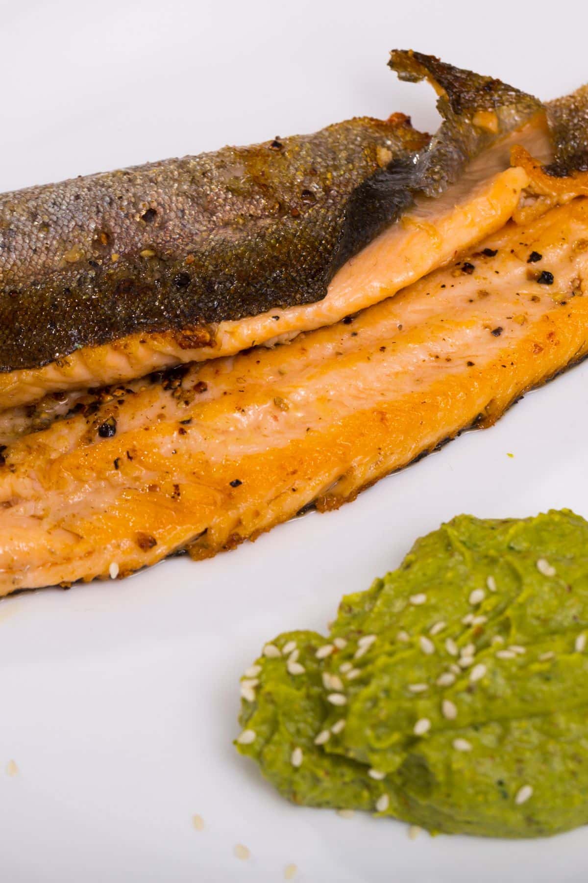 two pieces of grilled trout with broccoli puree.