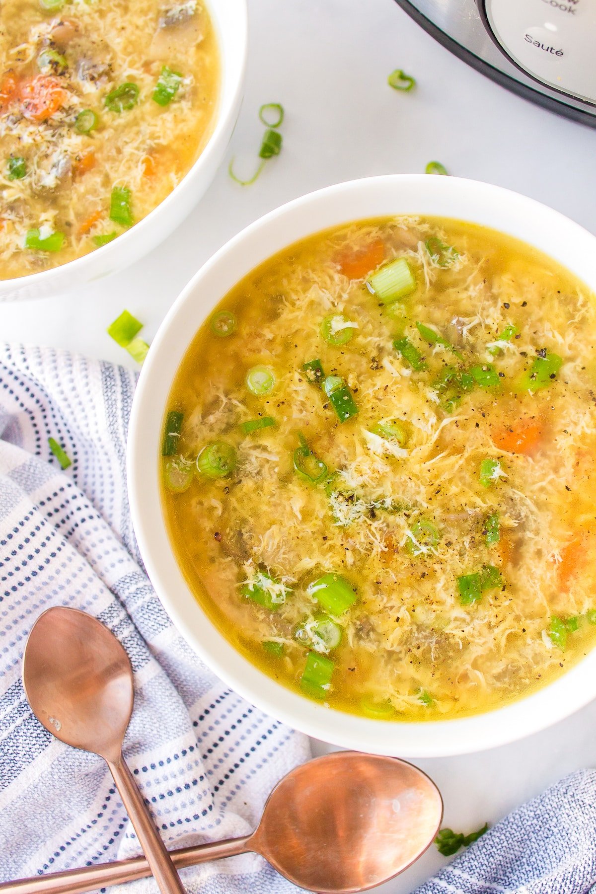 overhead shot of two bowls of egg drop soup.