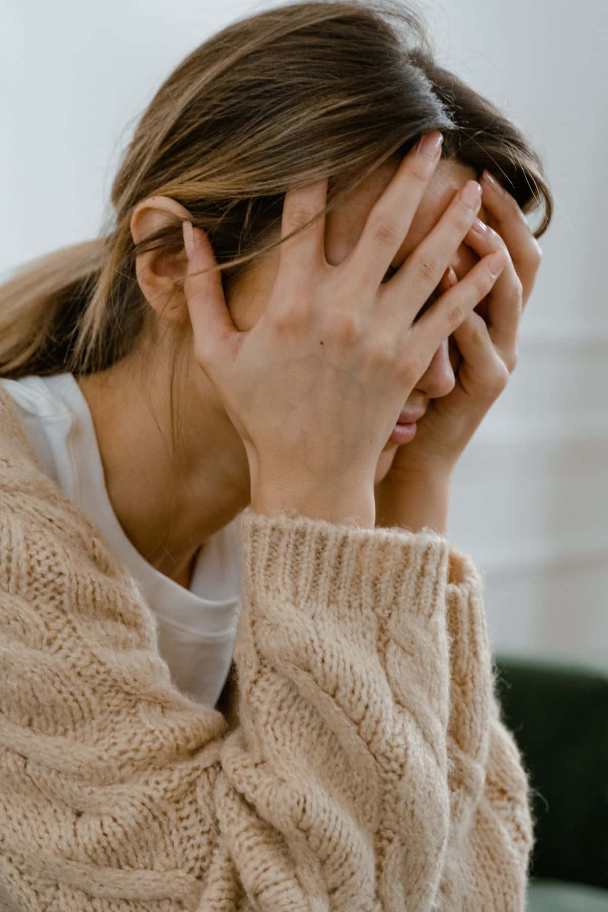 a woman holding her head in her hands.