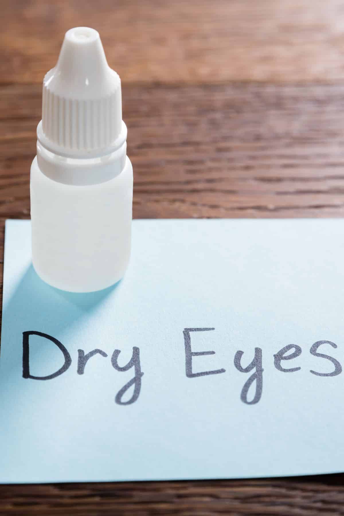 eye drops on table with note that says dry eyes.