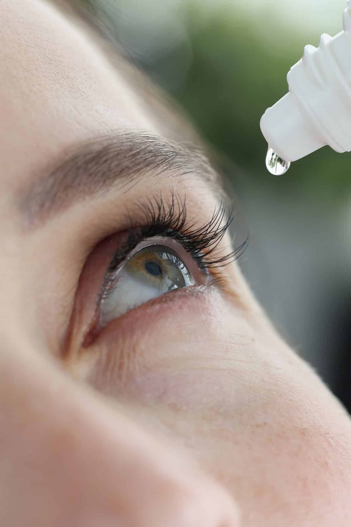 woman putting drops in eye.