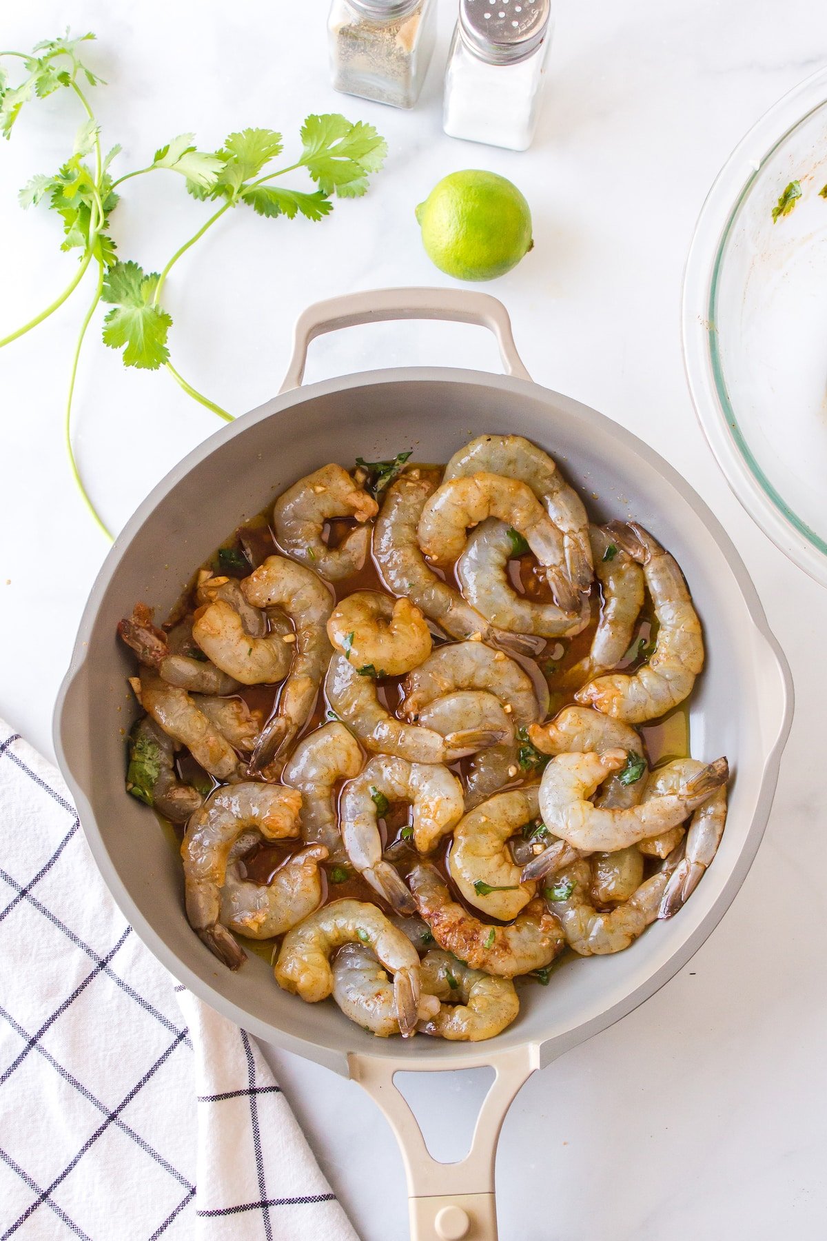 raw, marinated shrimp cooking in a skillet.
