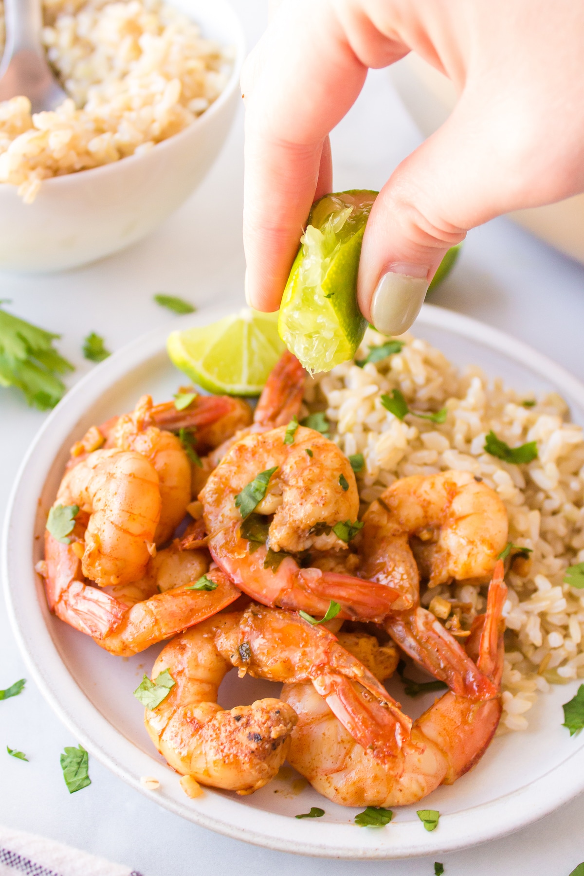 squeezing lime on a plate of costco cilantro shrimp. 