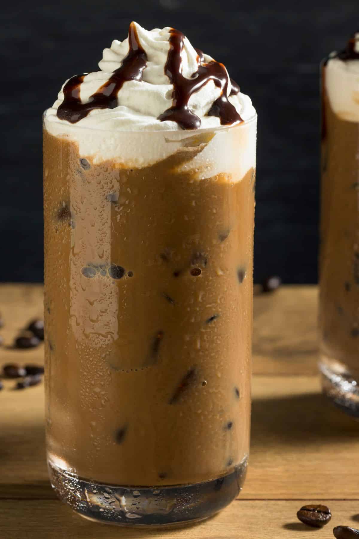 a dairy-free iced mocha topped with whipped cream and chocolate syrup.