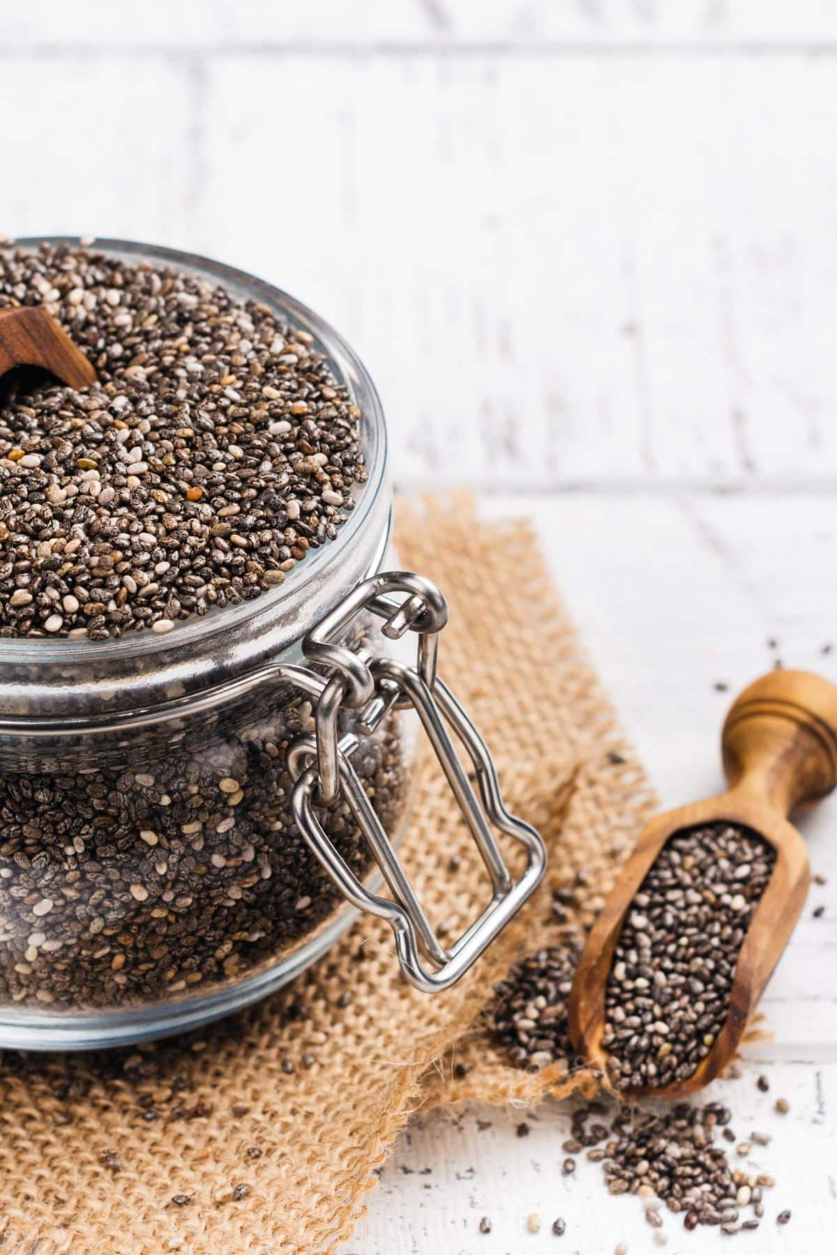 a jar of chia seeds next to a small scoop.
