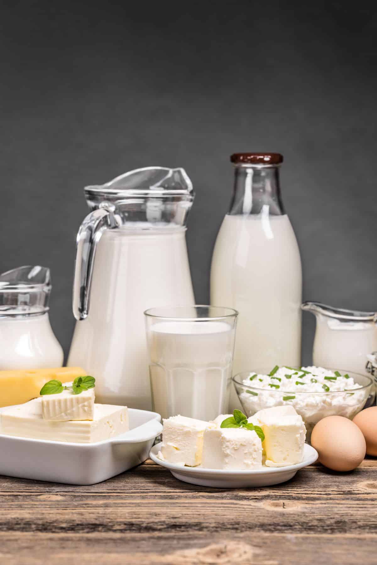 a variety of dairy products on a wooden table.