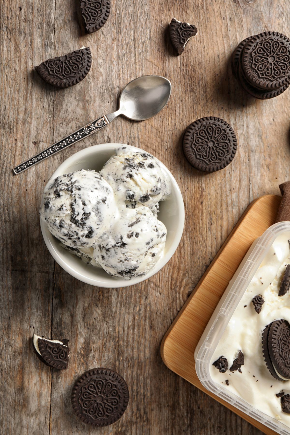 bowl of cookies and cream ice cream on table with spoon.