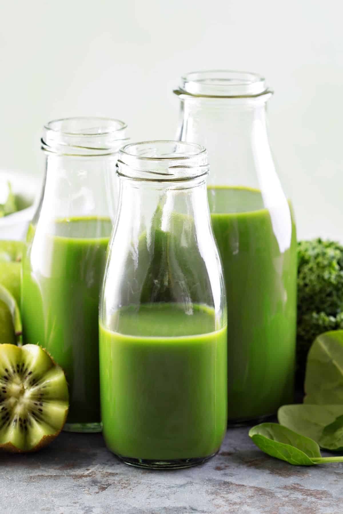 three green juices in jars on table.