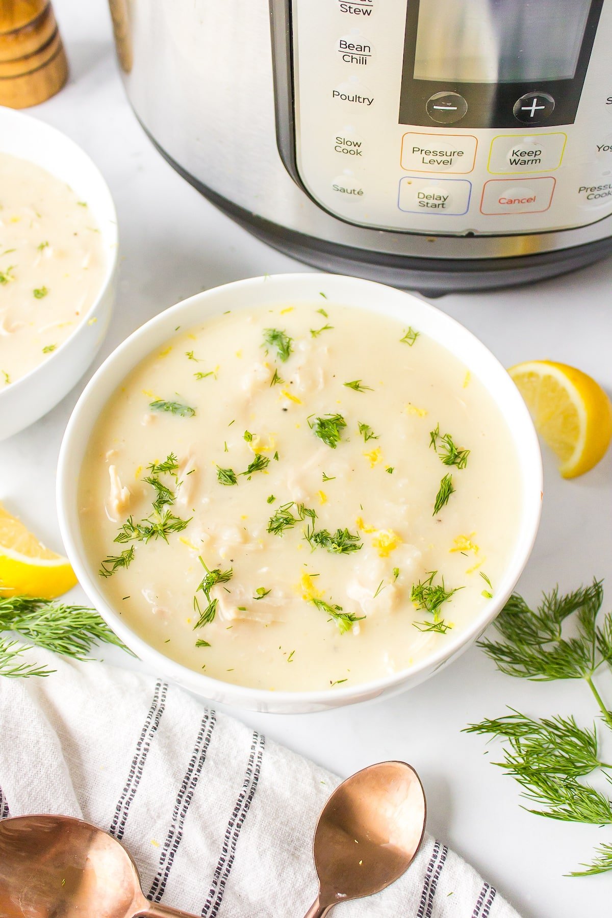 a bowl of instant pot avgolemono soup topped with fresh dill.