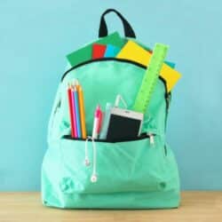 green backpack on table for back to school.