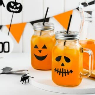 two pumpkin spice mocktails in jack-o-lantern jars.