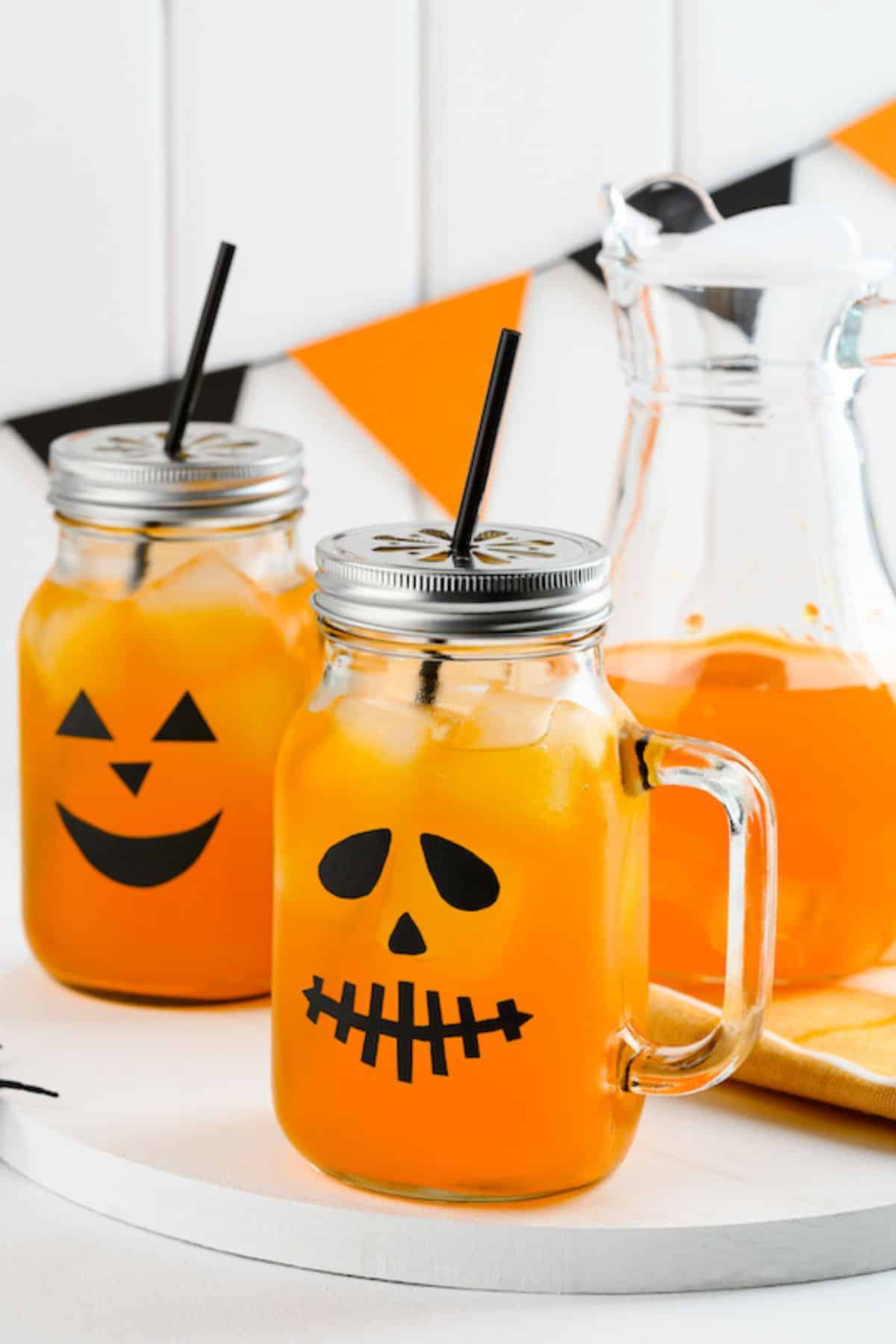two pumpkin spice mocktails in jack-o-lantern jars.