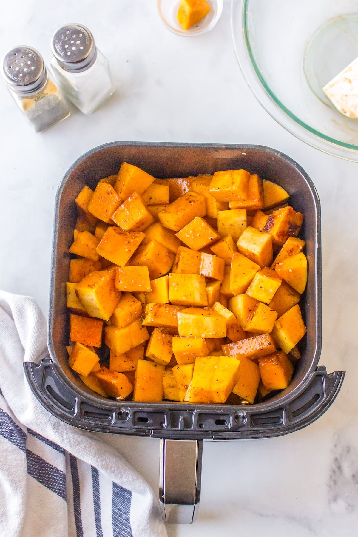 air fryer butternut squash in basket ready to be baked.