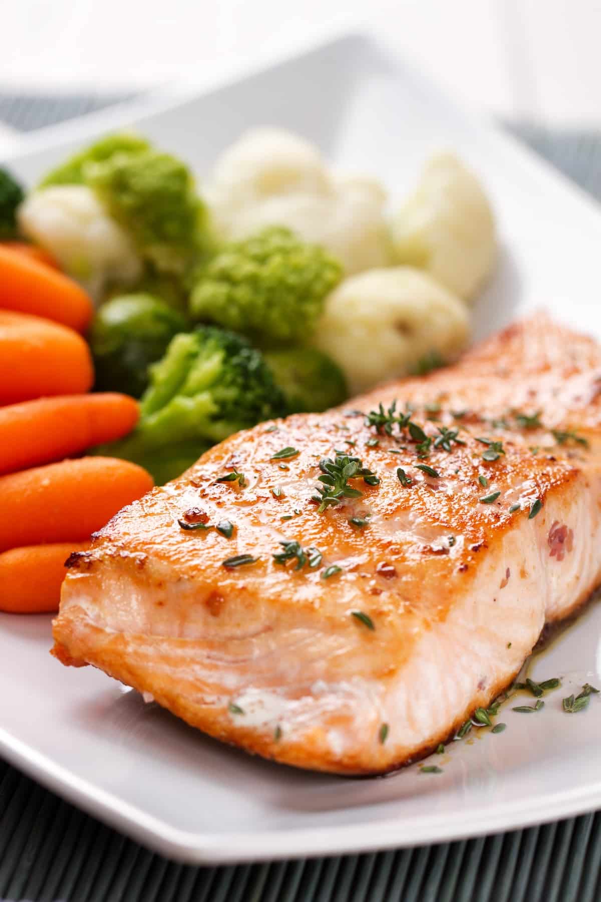air fryer frozen salmon served on plate with veggies.