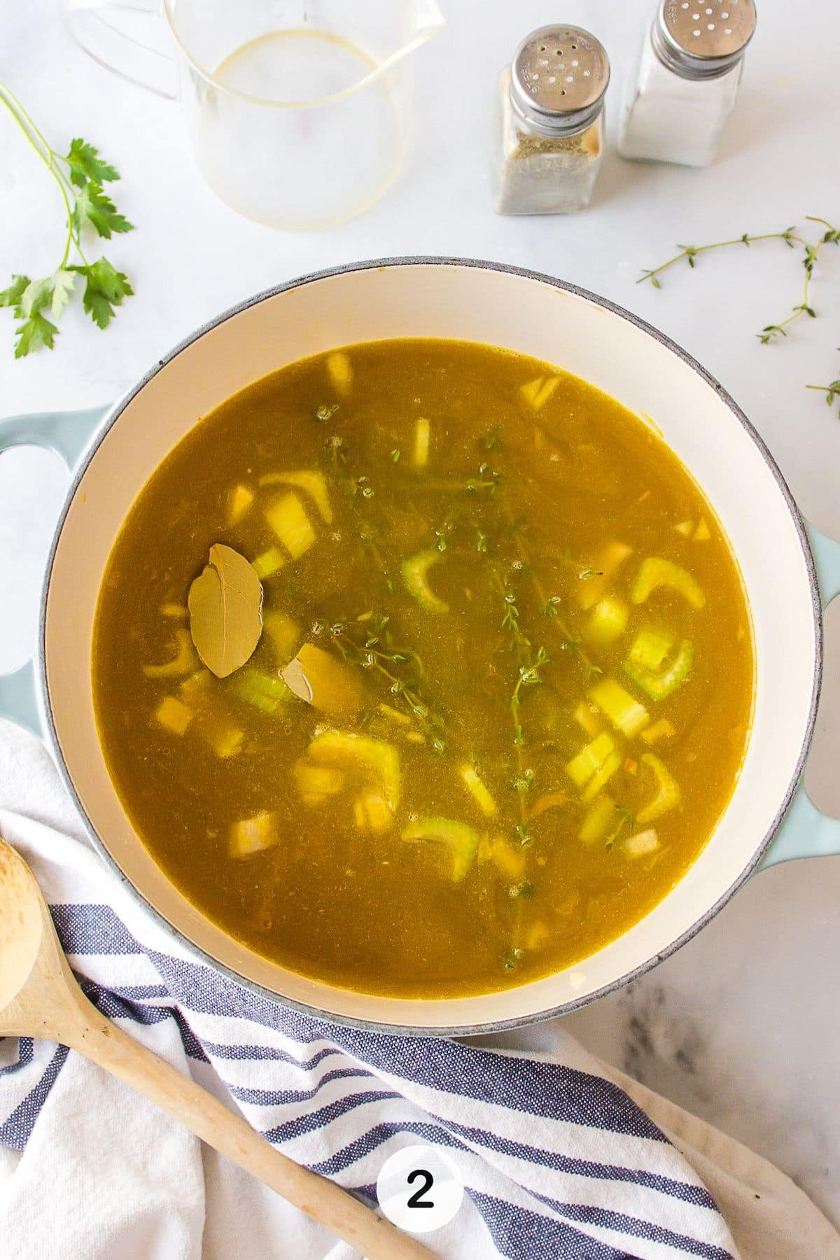 broth and herbs in pot with bone broth.
