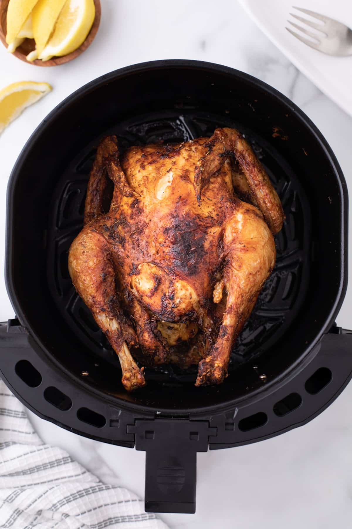 air fryer whole roasted chicken rotisserie style in basket.