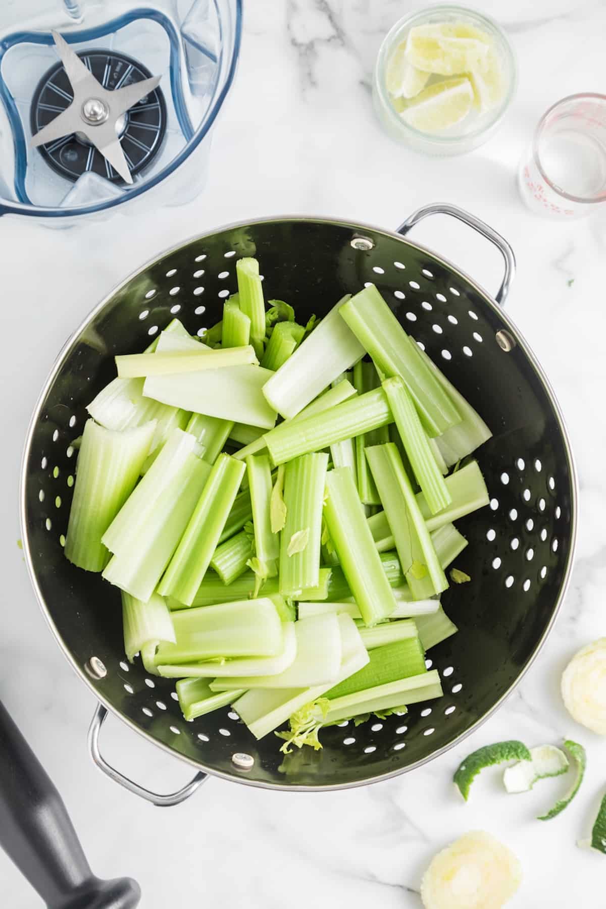 ingredients for making celery juice in a colander ready to juice.