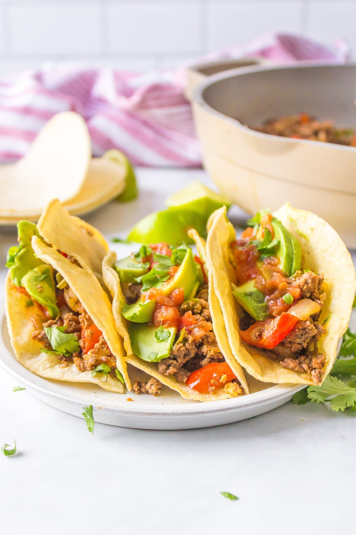 three bison tacos on a white plate.