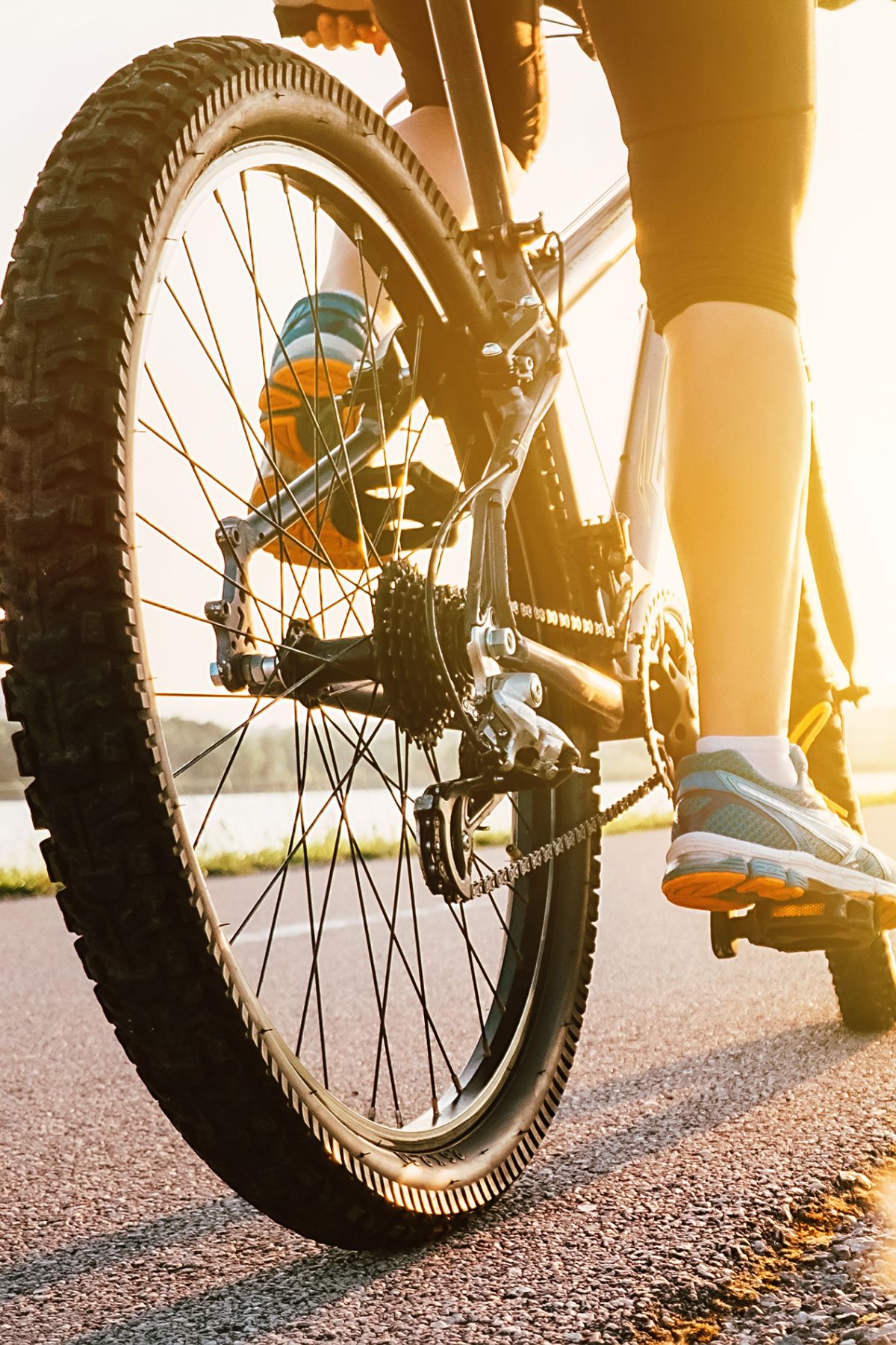 close up of a tire and leg of woman cycling.
