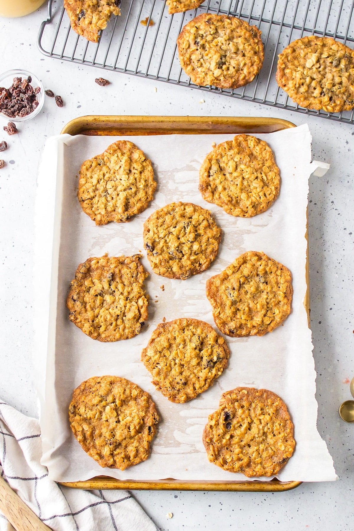 a cookie sheet full of baked oatmeal cookies.