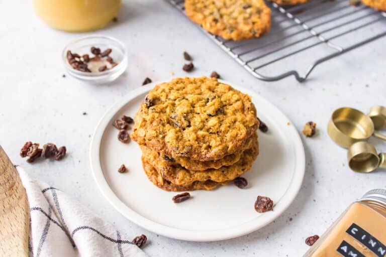 four oatmeal cookies stacked on a white plate.