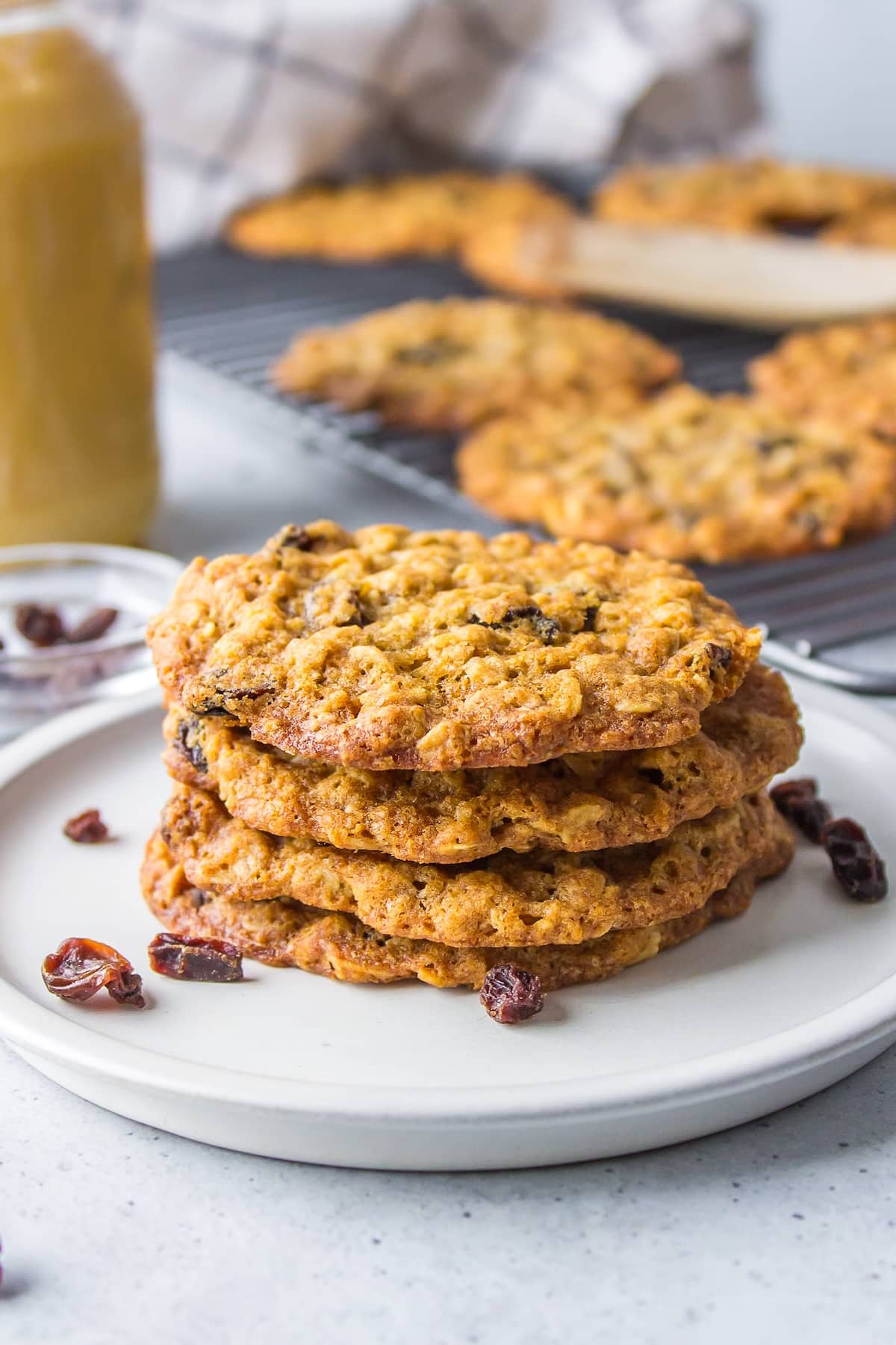 four oatmeal cookies stacked on a white plate.