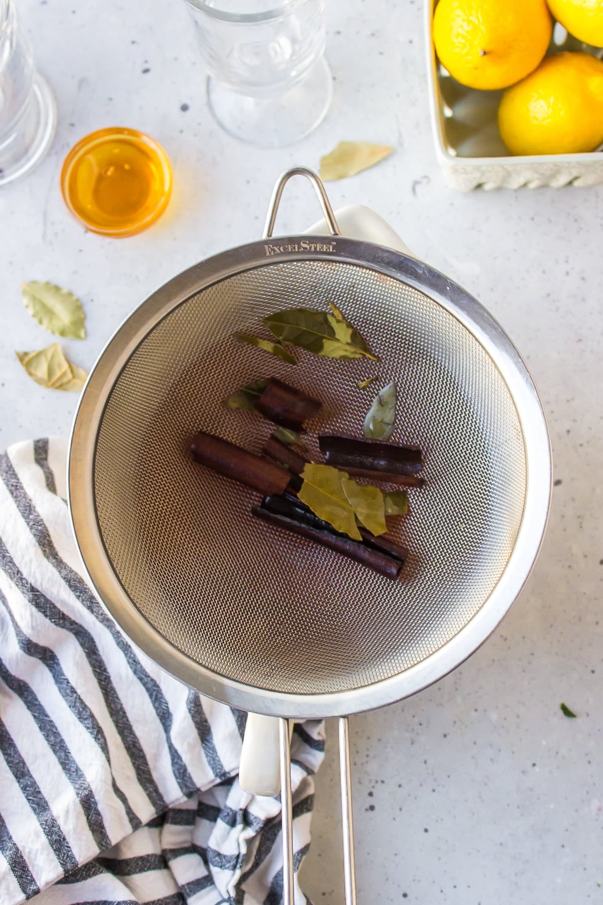 bay leaves and cinnamon sticks in a strainer.