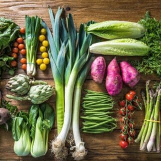 a variety of vegetables on a wooden table.