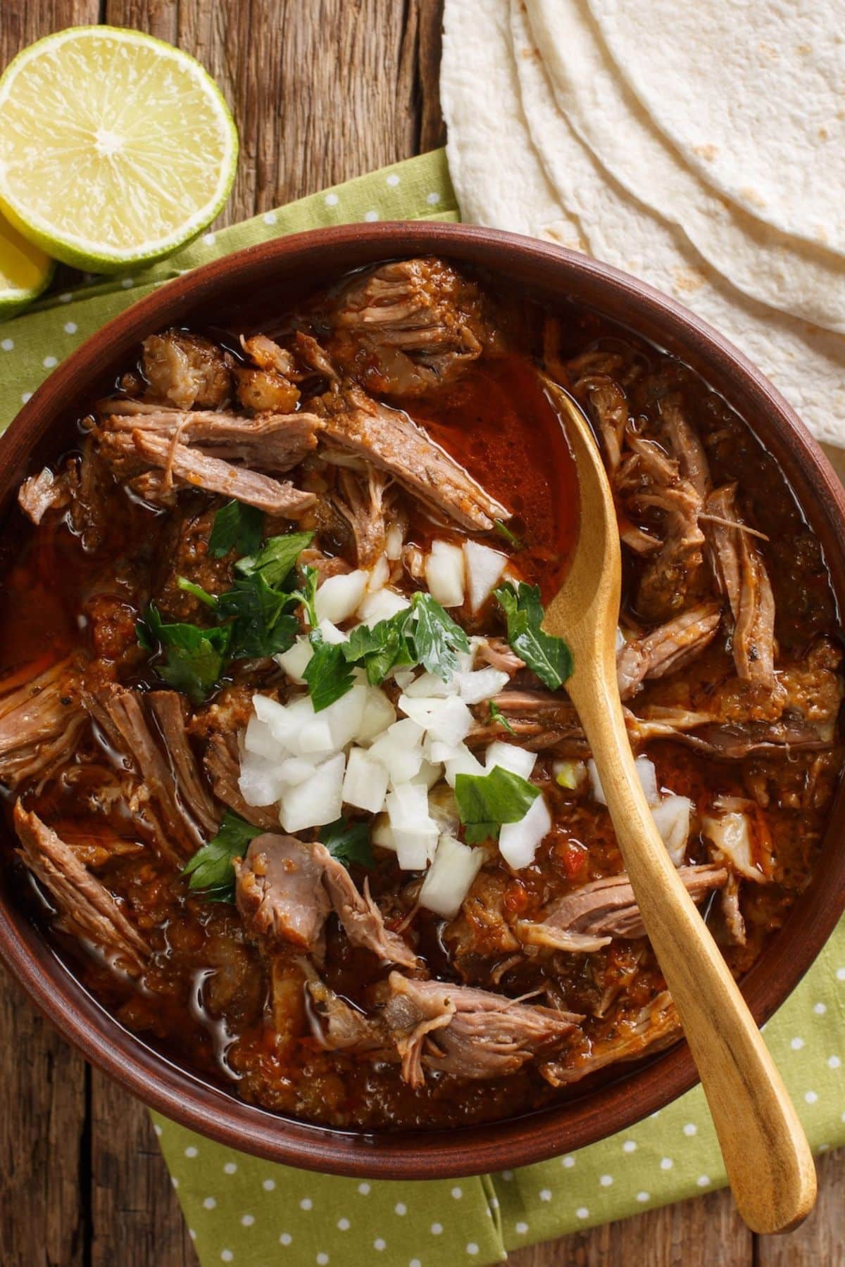 bowl of mexican mirria stew topped with onions.