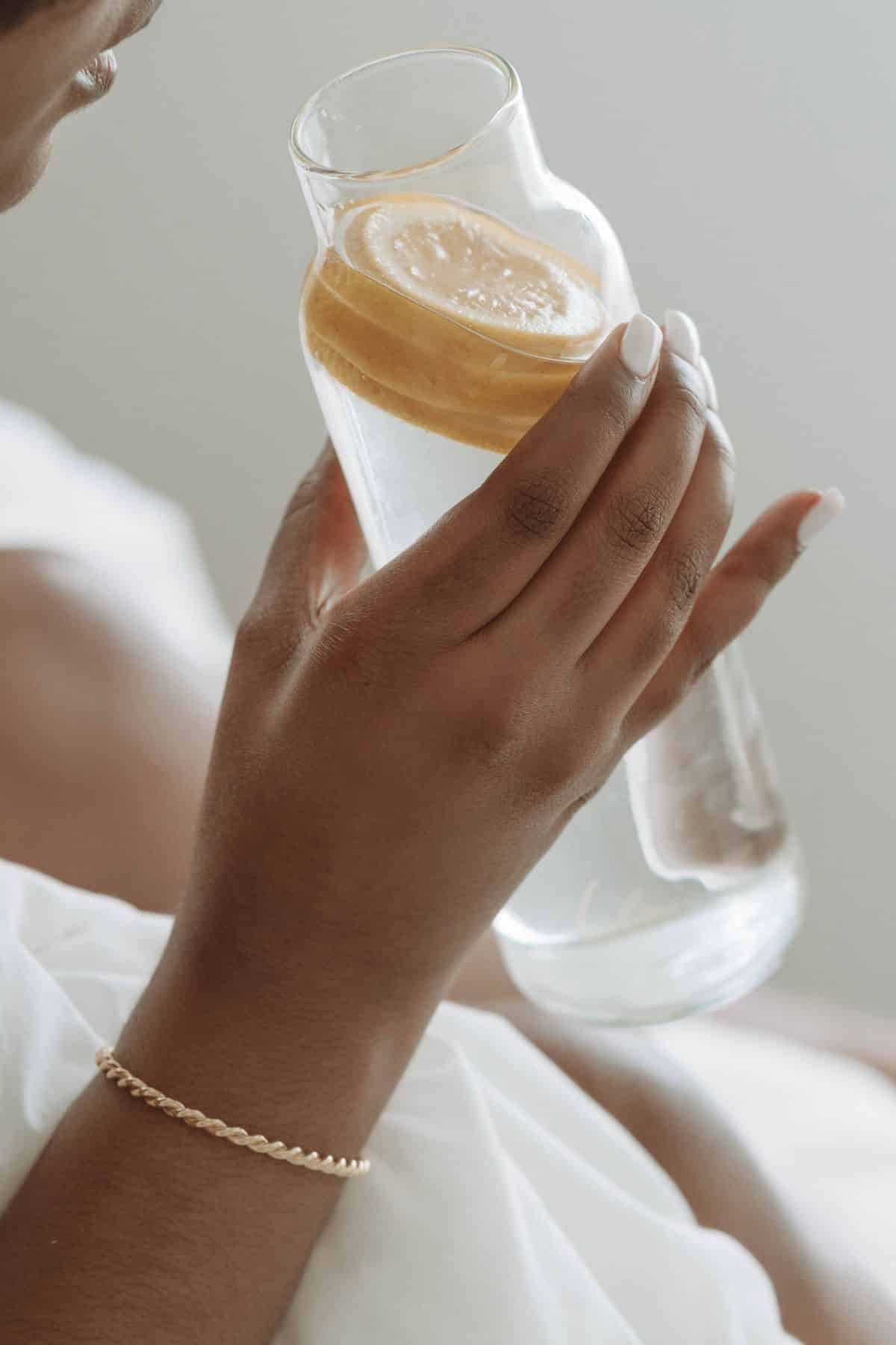 a woman drinking lemon water.