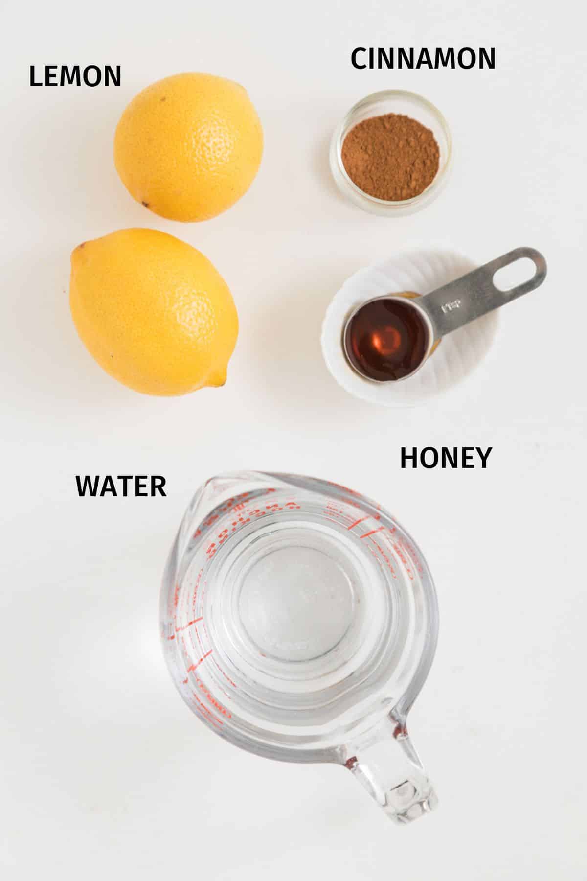 ingredients for lemon cinnamon water on table with labels.