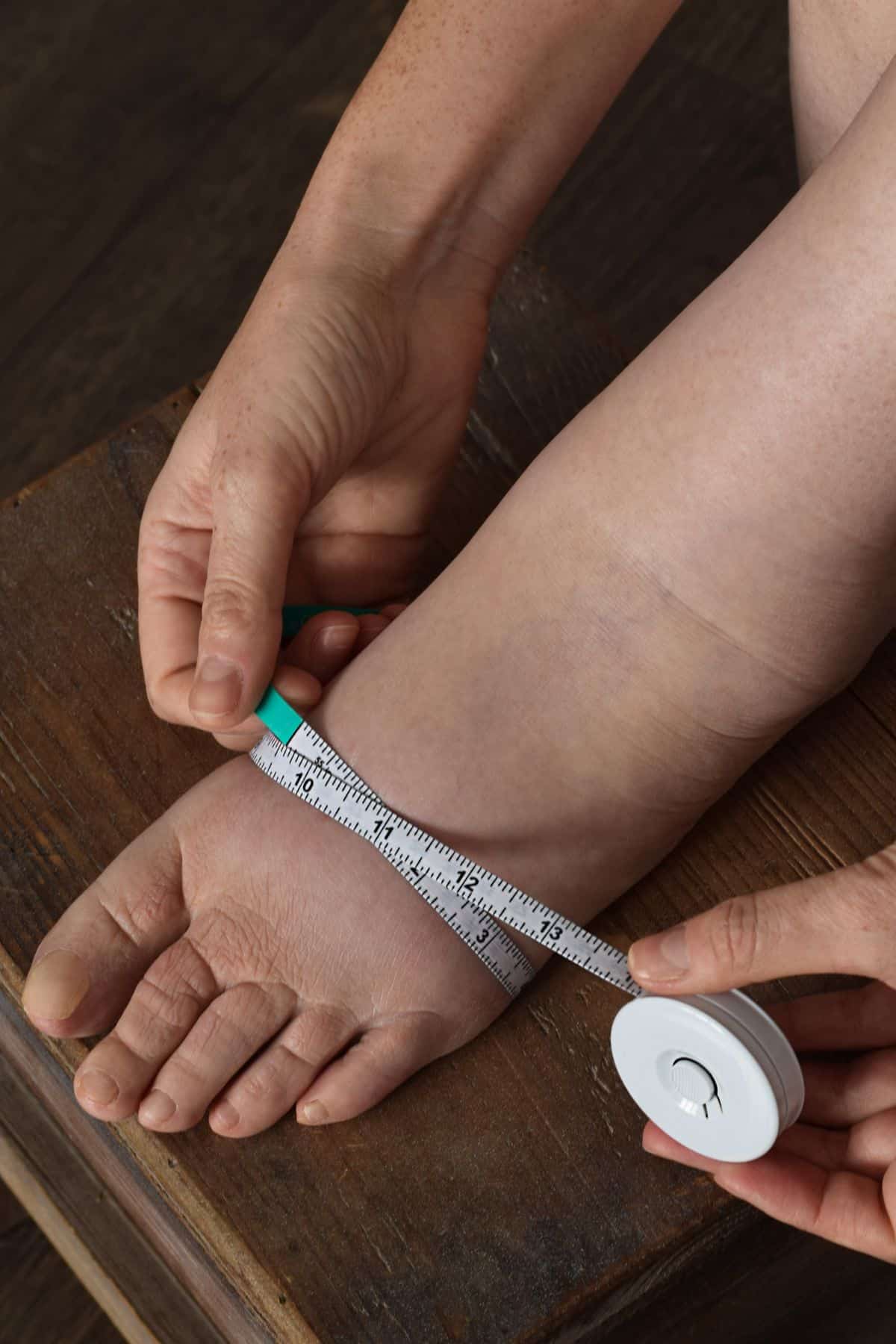 a woman measuring her swollen foot.