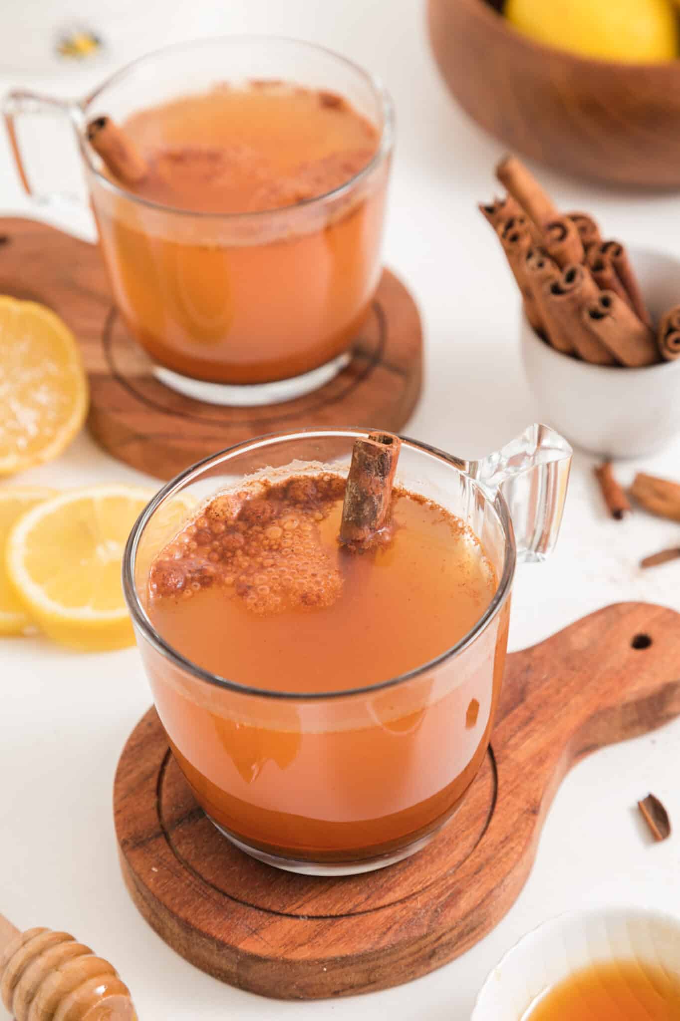 two mugs of lemon water with ground cinnamon.