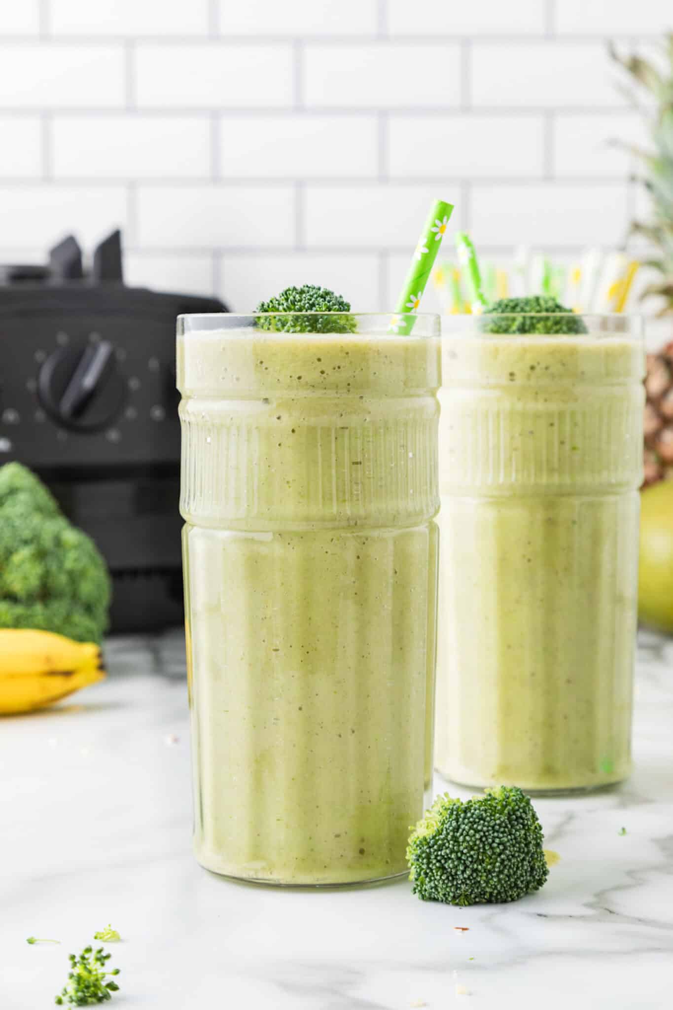 green broccoli pineapple smoothie in tall glass.