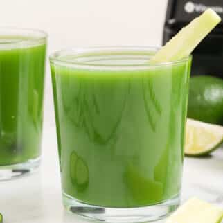 two glasses green cucumber juice on table.