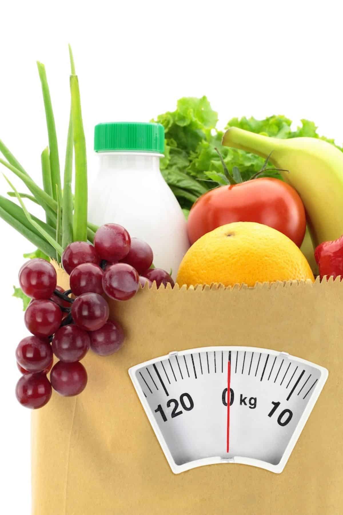 shopping bag with healthy fruits and veg and scale.