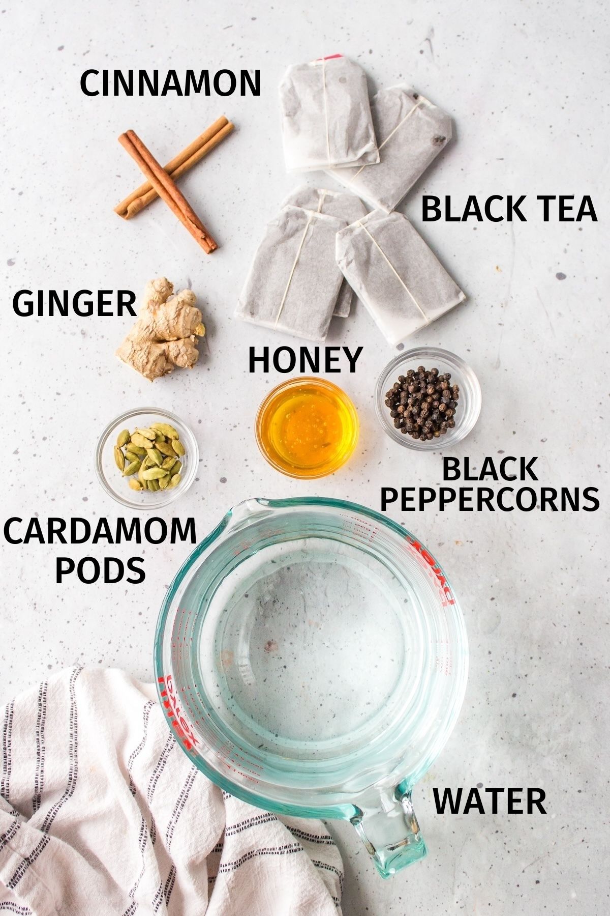 ingredients for chai tea concentrate on a white counter.