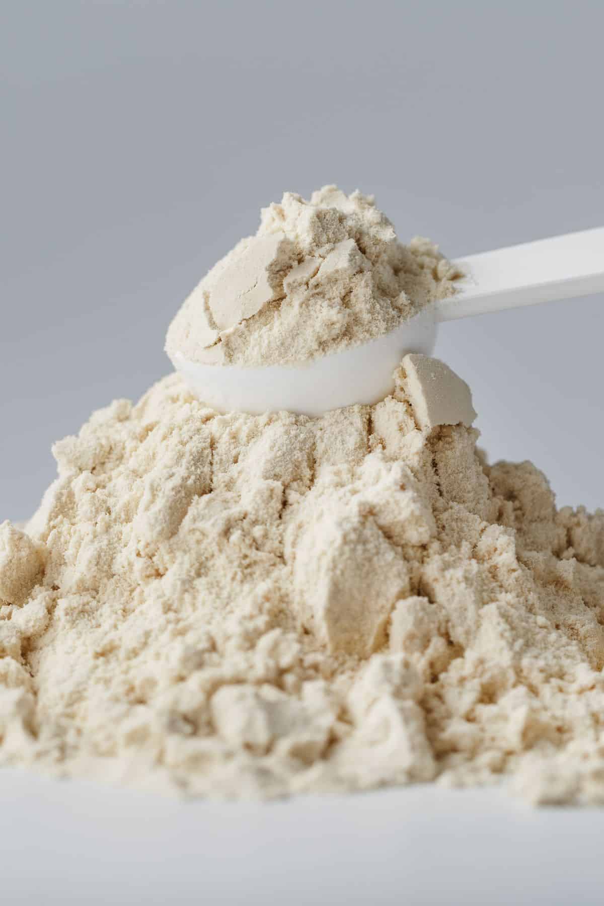 a scoop of soy protein isolate on top of a mound of soy protein isolate.