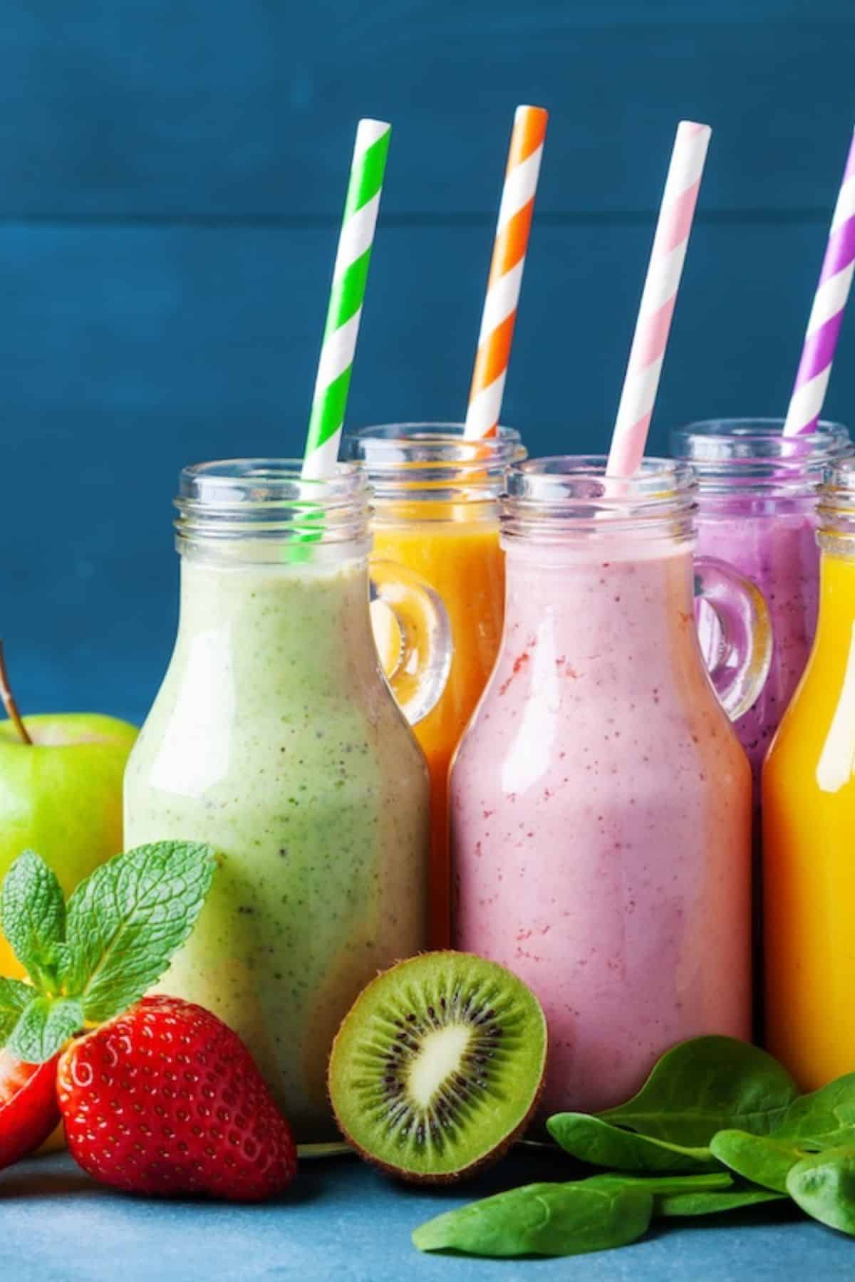 colorful fruit smoothies on table with fresh fruits.